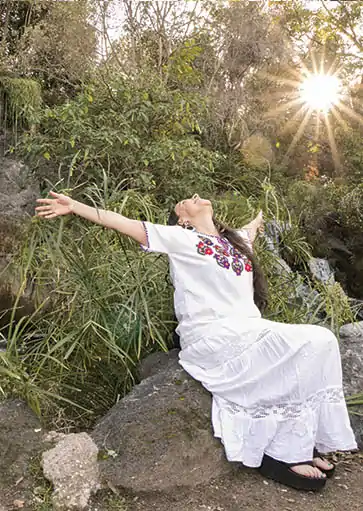 Erika Buenaflor in a white dress welcoming the suns rays