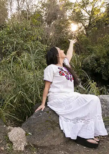 Erika Buenaflor in a white dress holding the sun