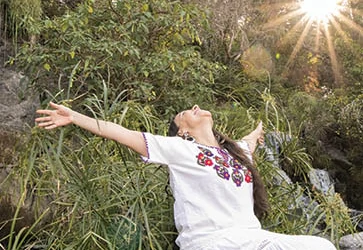 Erika Buenaflor in a white dress welcoming the suns rays