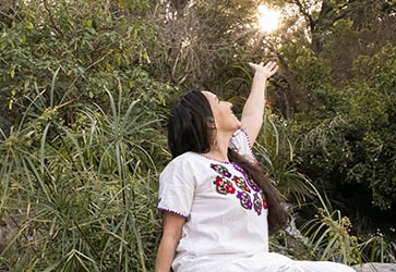 Erika Buenaflor in a white dress holding the sun