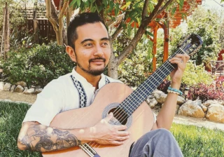 Miguel Buenaflor playing guitar in the garden